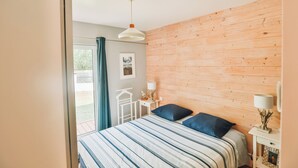 Een slaapkamer met een bed, een nachtkastje, een lamp en een raam met gordijnen.