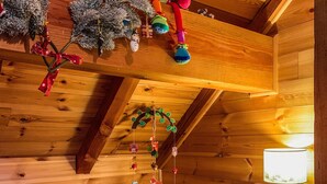 Een gezellig houten kamer met ledikant, een teddybeer en een hangende mobiel.