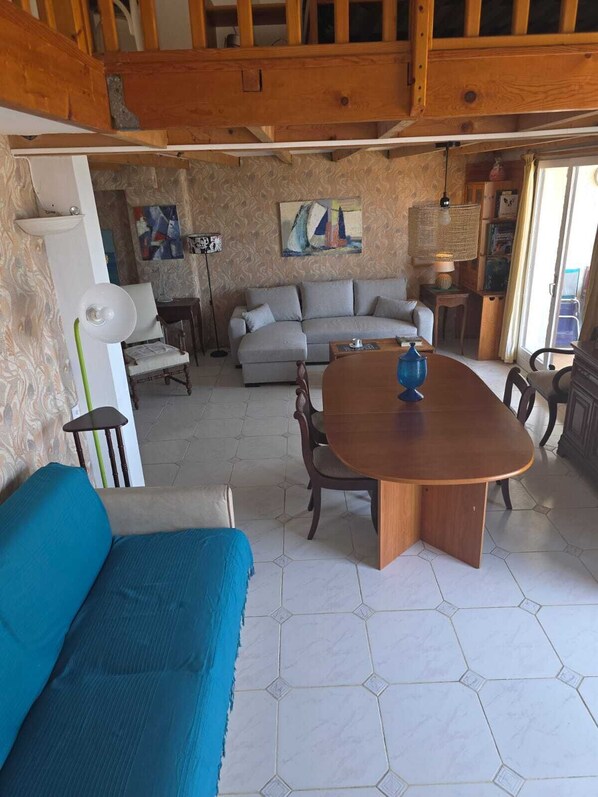 Una sala de estar con sofá, mesa de comedor y un diván.