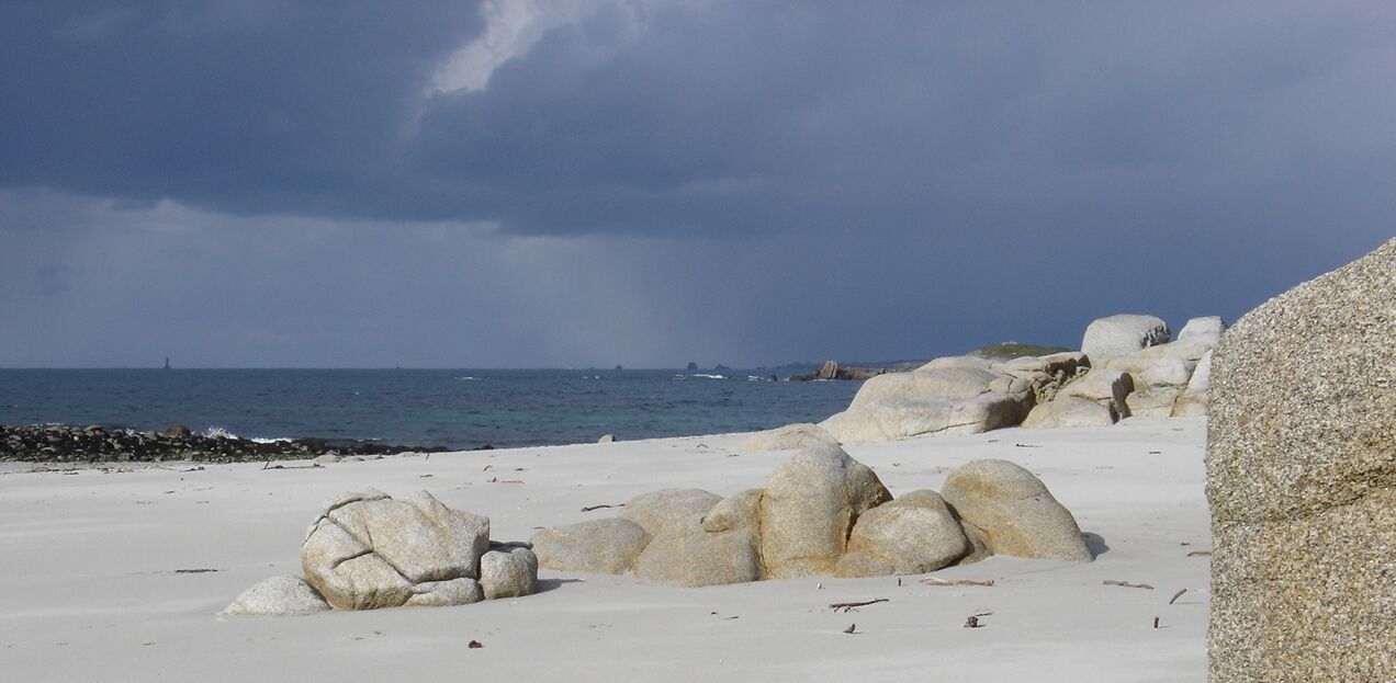 Ein Strand mit großen weißen Felsen und Blick auf den Ozean.