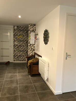 A room with a patterned wall, a radiator, a door, and a bench. - House *** in Mont Saint Michel bay 2 to 5 people (Saint-Broladre)