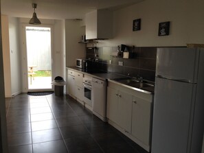 A modern kitchen with white cabinets, a stainless steel refrigerator, and a microwave. - House *** in Mont Saint Michel bay 2 to 5 people (Saint-Broladre)