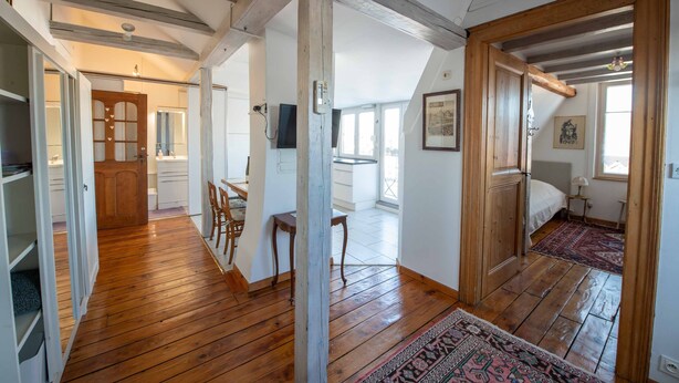 A spacious room with wooden floors, a bed, a desk, and a chair. - At the gates of Strasbourg charming apartment in lush greenery 4 per. (Eckbolsheim)