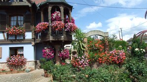 Un bâtiment européen traditionnel doté d’un balcon orné de jardinières suspendues.