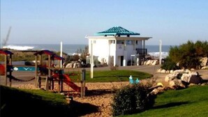 A beachside building with a green roof, a playground with slides, and a view of the ocean. - Charming house, in a green setting, on the Landaise Coast (Labenne)