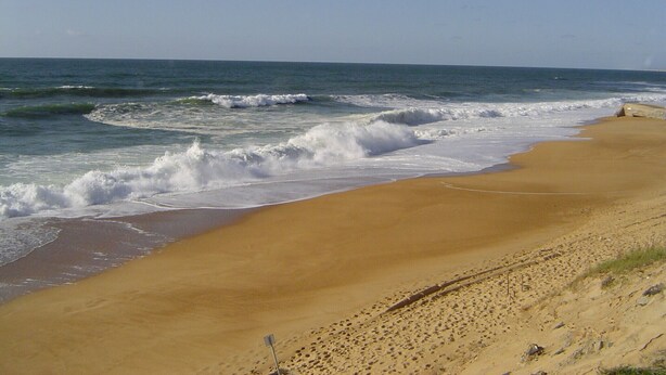 A beach with waves crashing onto the shore, a clear sky, and a sandy landscape. - Charming house, in a green setting, on the Landaise Coast (Labenne)