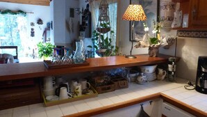 A kitchen with wooden countertops, a hanging light fixture, and various kitchen items. - Charming house, in a green setting, on the Landaise Coast (Labenne)