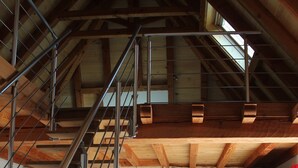 Un intérieur rustique avec un escalier en bois, une cheminée et un coin repas.