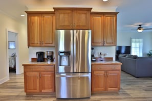 Enjoy a well-equipped kitchen with a large refrigerator, water dispenser, and ample cabinetry.