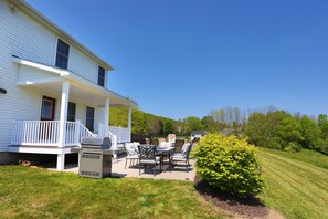 Enjoy al fresco dining on the covered porch, complete with a table and chairs, and grill for outdoor cooking.