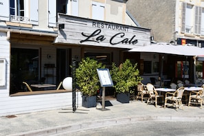 A restaurant named 'La Cote' with outdoor seating and a signboard.