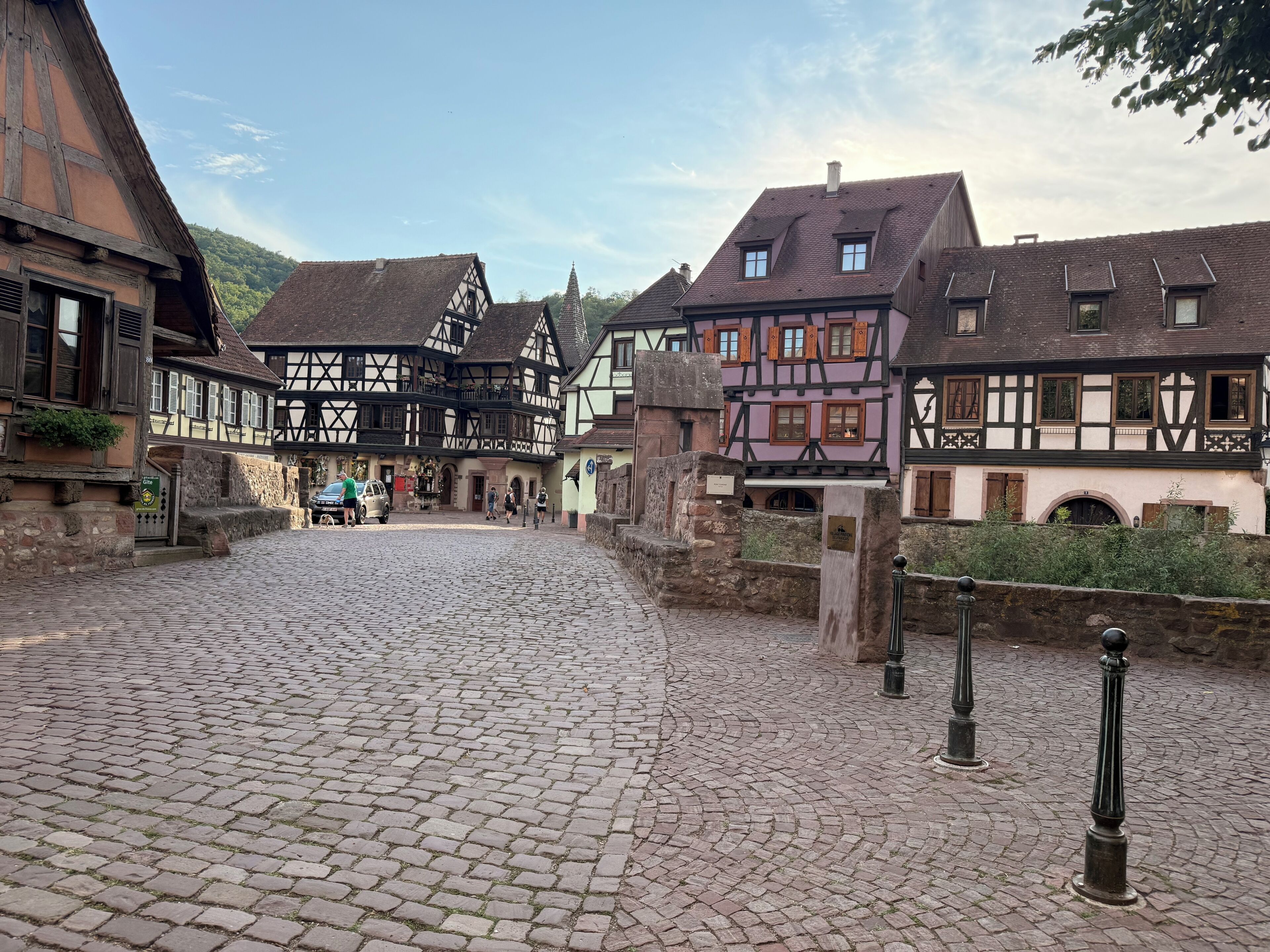A cobblestone street in a historic town with traditional half-timbered buildings.