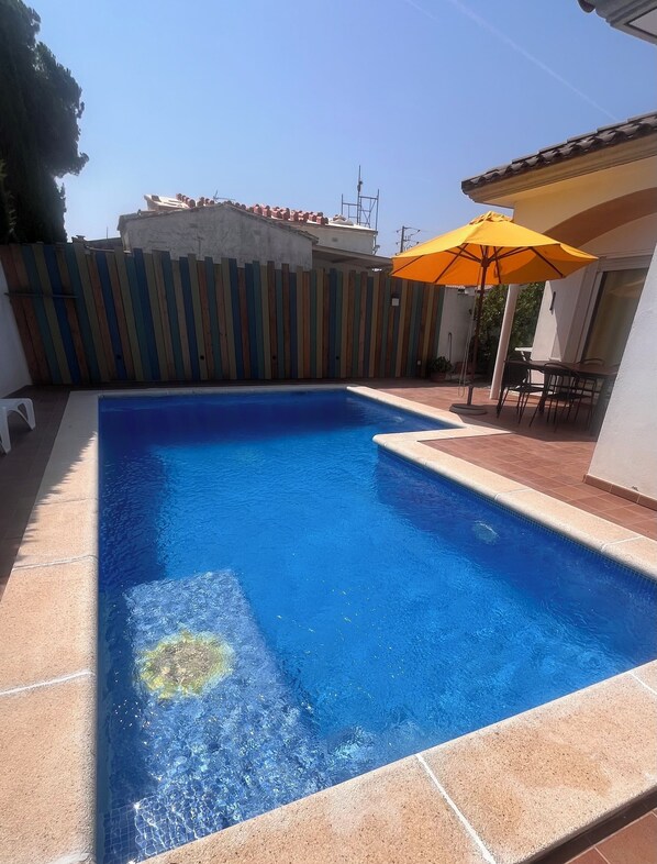 A rectangular swimming pool with clear blue water, surrounded by a tiled deck. A wooden fence with vertical slats is visible in the background. - NON-SEMI-DETACHED HOUSE WITH PRIVATE POOL WIFI AIR CONDITIONING NEAR BEACH RIELLS (L'Escala)