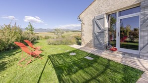 A house with a large glass door, a grassy yard, and red chairs. - Loft in Provence in Moustiers Sainte Marie and near the Sainte Croix Lake (Moustiers-Sainte-Marie)