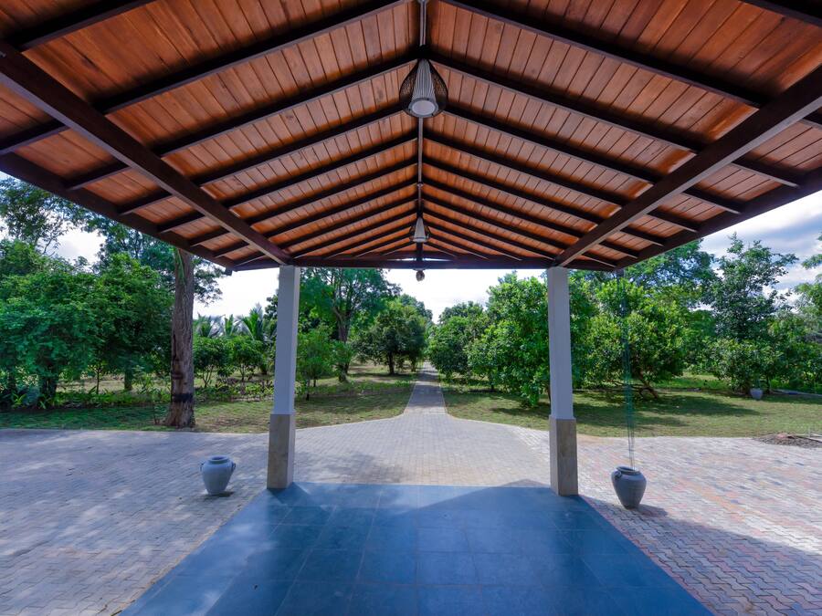 A covered pavilion with a tiled floor and two large vases.