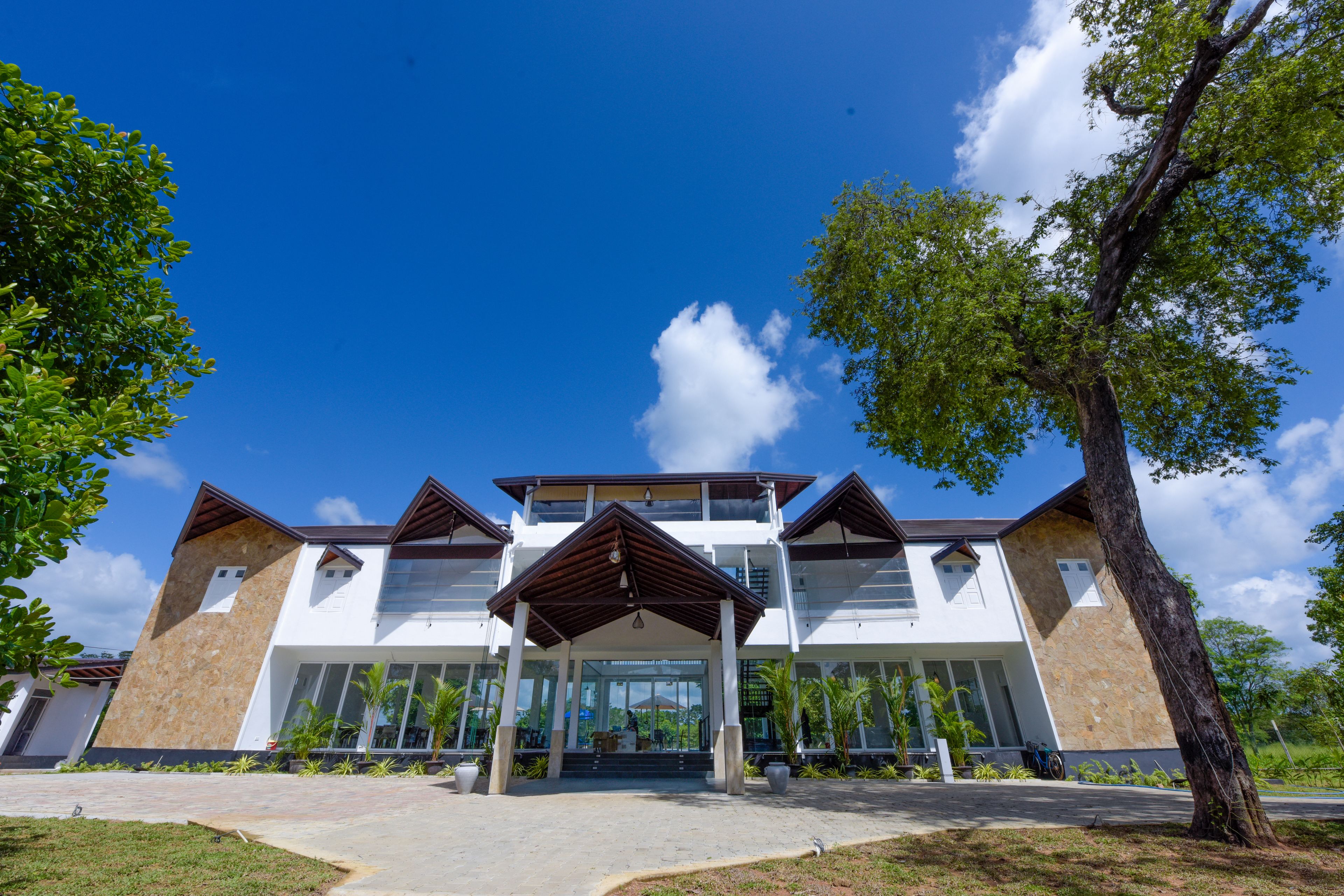 A modern building with a central entrance, large windows, and a covered walkway.