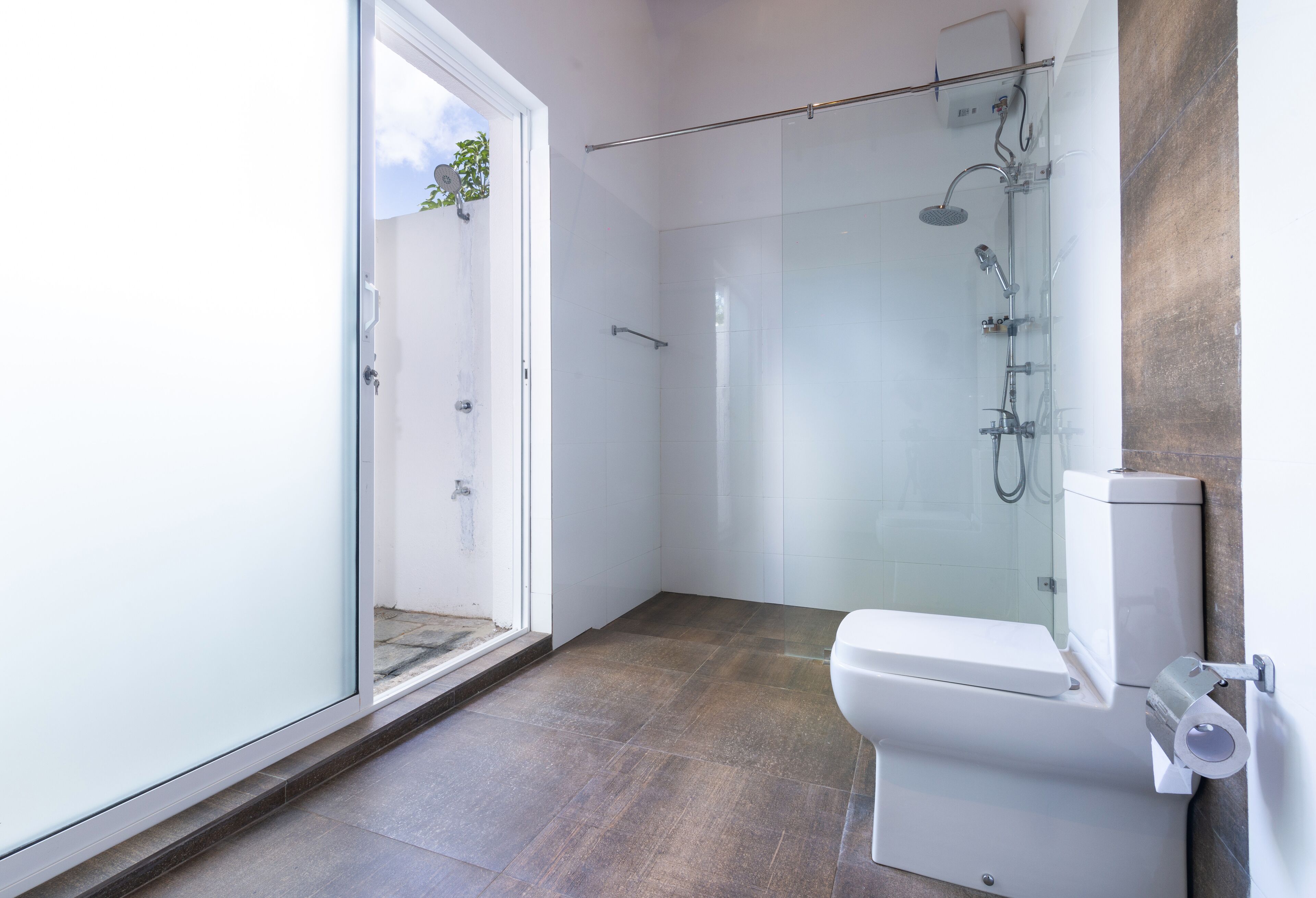 Une salle de bain moderne avec une douche à parois de verre, des toilettes et un porte-serviettes.