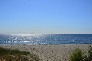 Una playa con cielo despejado y mar tranquilo.