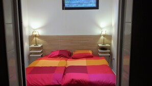 A room with a bed, two bedside tables, and a wall-mounted TV. - Nice air-conditioned 3rooms 3***in ground floor, private terrace , swimming pool (Saint-Raphaël)