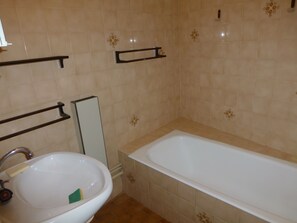 Ensemble baignoire-douche, séchoir à cheveux, bidet, papier de toilette