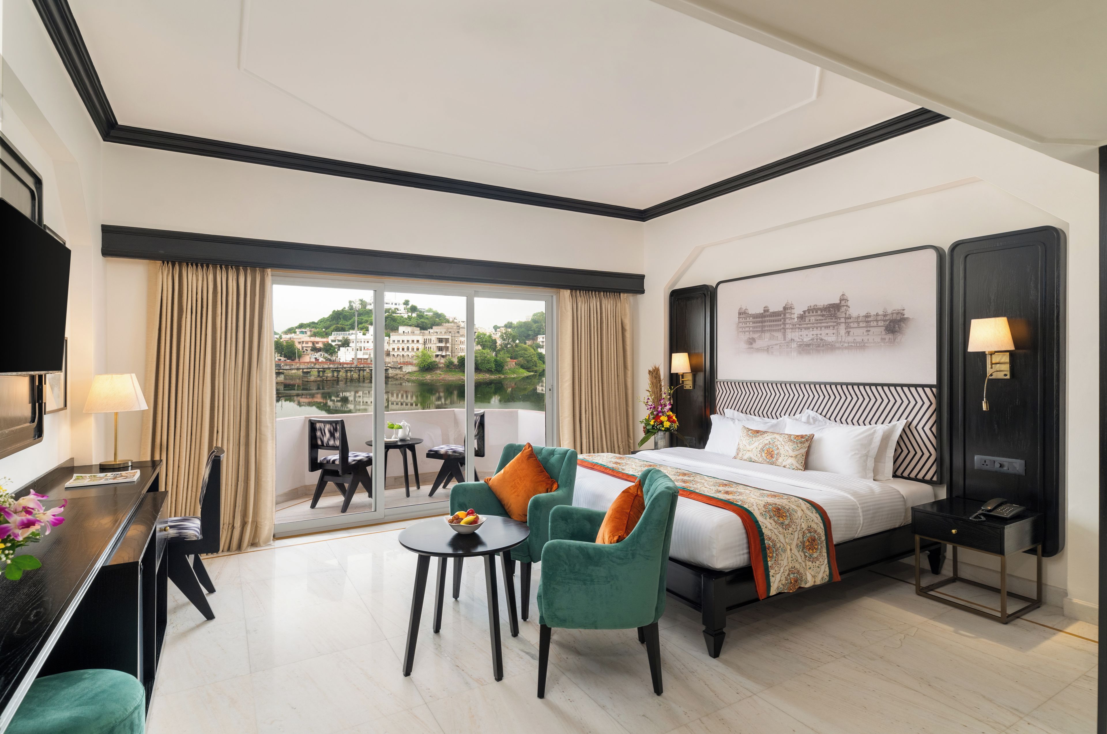 Une chambre d’hôtel avec un grand lit, un bureau, une chaise, une petite table et une vue sur le paysage urbain par la fenêtre.