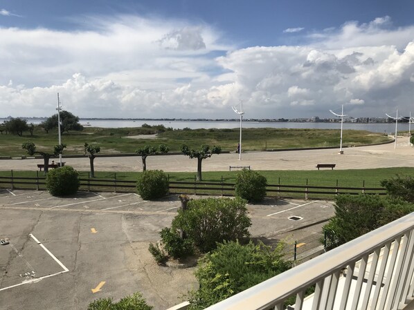 A parking area with trees and a view of the water.
