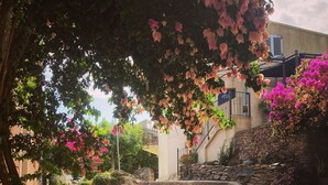 A stone staircase leading up to a building with a stone wall and a metal railing. - The village candy (Meria)