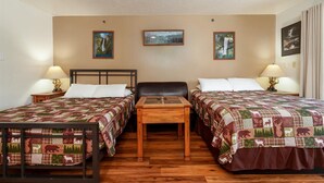 A hotel room with two beds, a wooden table, and two lamps.