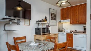 A compact kitchen with wooden cabinets, a microwave, a stove, and a sink.