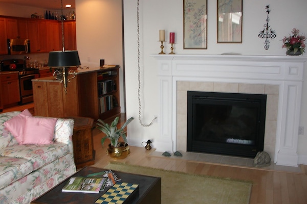 Living room with two sided fireplace looking into kitchen