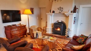 Una sala de estar con chimenea, sofás de cuero, una mesa de centro y un tapete estampado.