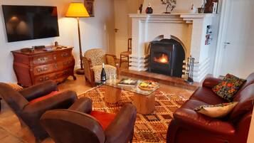 A living room with a fireplace, leather sofas, a coffee table, and a patterned rug.