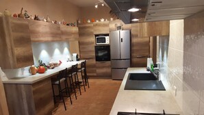 Una cocina moderna con estufa a gas, electrodomésticos de acero inoxidable y detalles de madera.