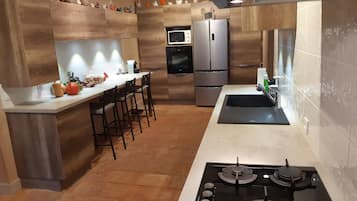 A modern kitchen with a gas stove, stainless steel appliances, and wooden accents.