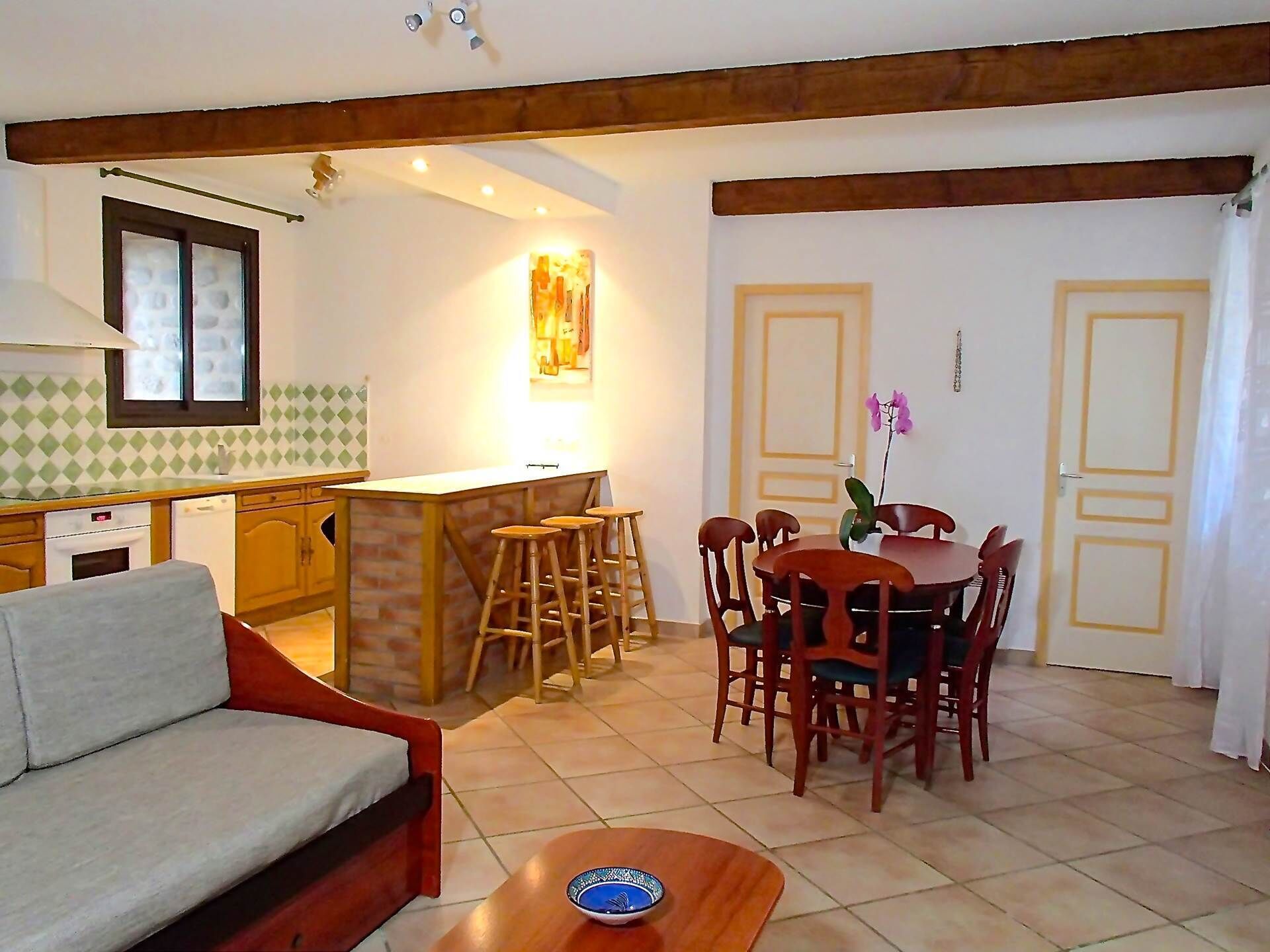 A compact living space with a kitchenette, dining area, and a sofa.