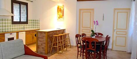 A compact living space with a kitchenette, dining area, and a sofa.