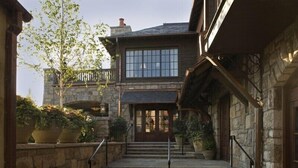 A stone building with a wooden staircase leading to a wooden door. There are potted plants on the steps and a balcony with a railing. - Minutes To Town, Wooded 2 Acre Retreat (Highlands)