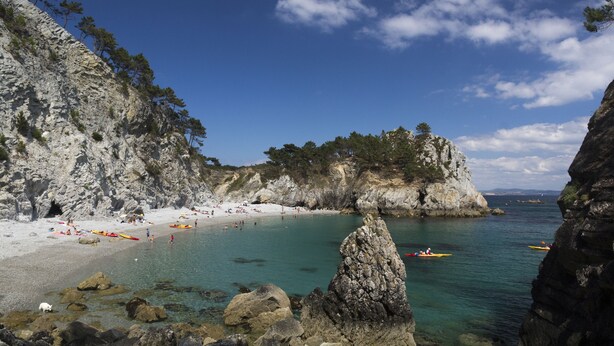 A rocky beach with clear turquoise water, kayaks, and people on the shore. - F2 Sea and Morgat beach view with small balcony (Crozon)