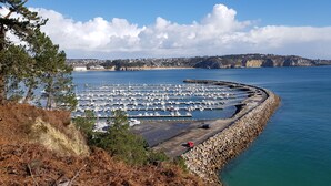 A marina with numerous boats docked, surrounded by rocky coastline and a clear sky. - F2 Sea and Morgat beach view with small balcony (Crozon)