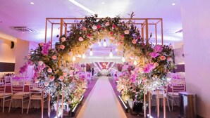 An indoor venue with a floral archway, tables, chairs, and a central aisle. - Go Hotels Iligan (Iligan)