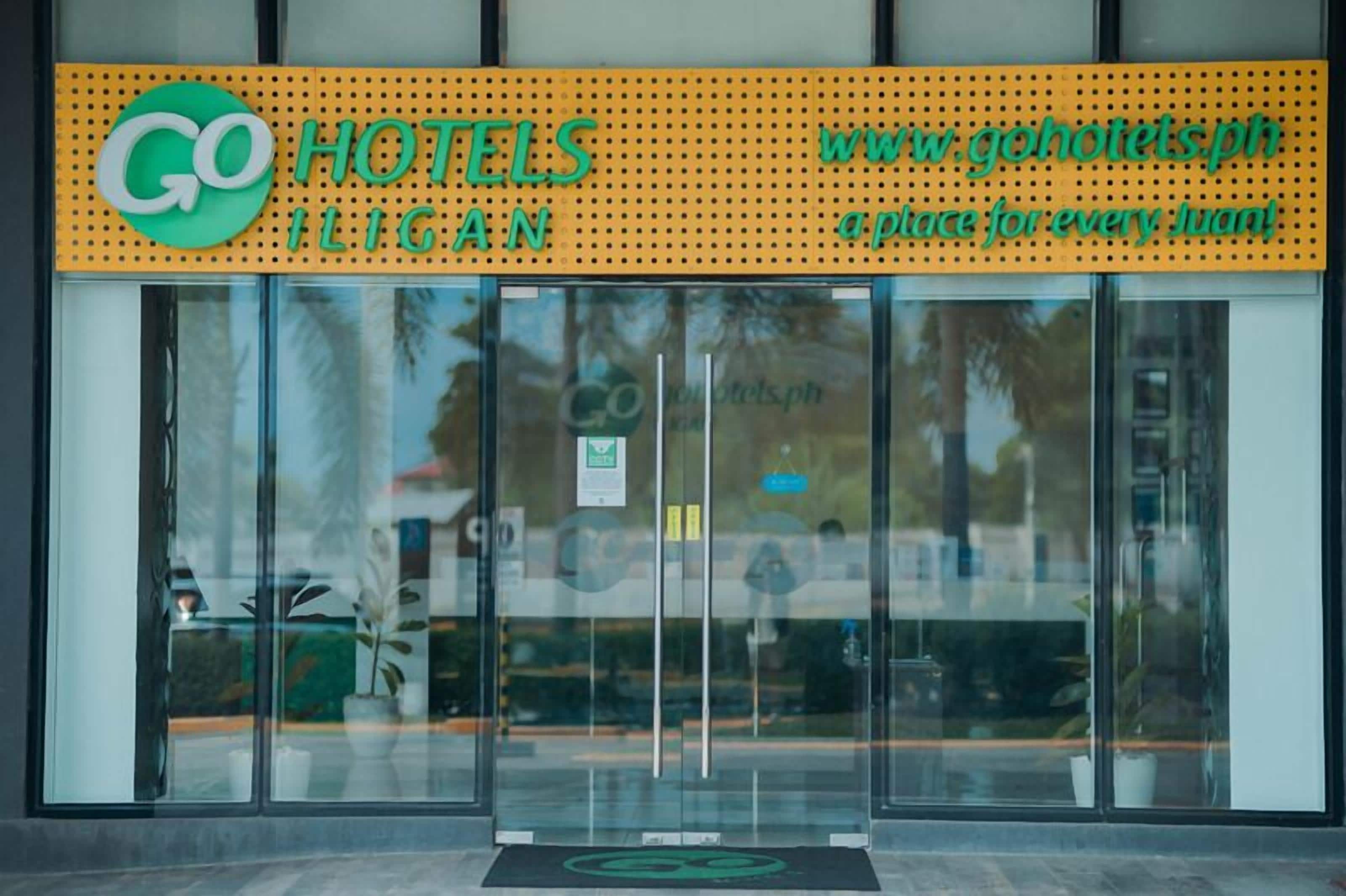 L'ingresso di un hotel con una porta in vetro, una targa con il nome dell'hotel e un indirizzo web.