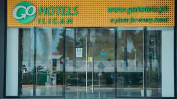 L'ingresso di un hotel con una porta in vetro, una targa con il nome dell'hotel e un indirizzo web.