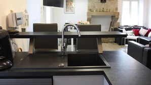 Uma cozinha moderna com uma ilha central, pia embutida e lareira de pedra.