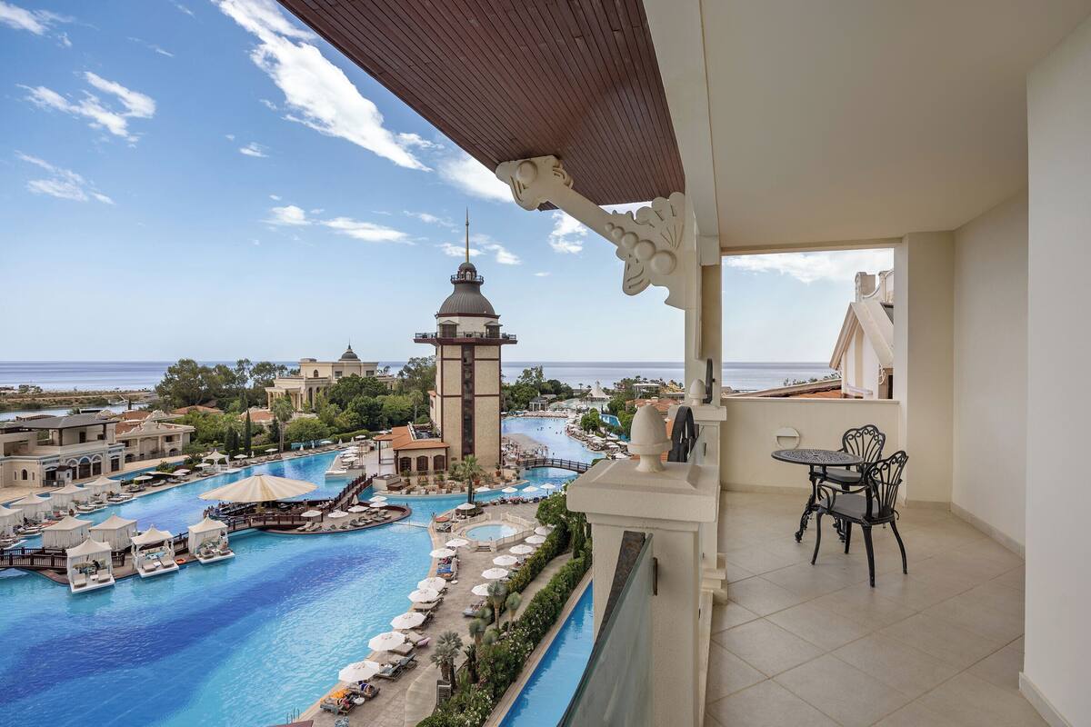 A resort with a large pool, a tower, and a view of the sea.