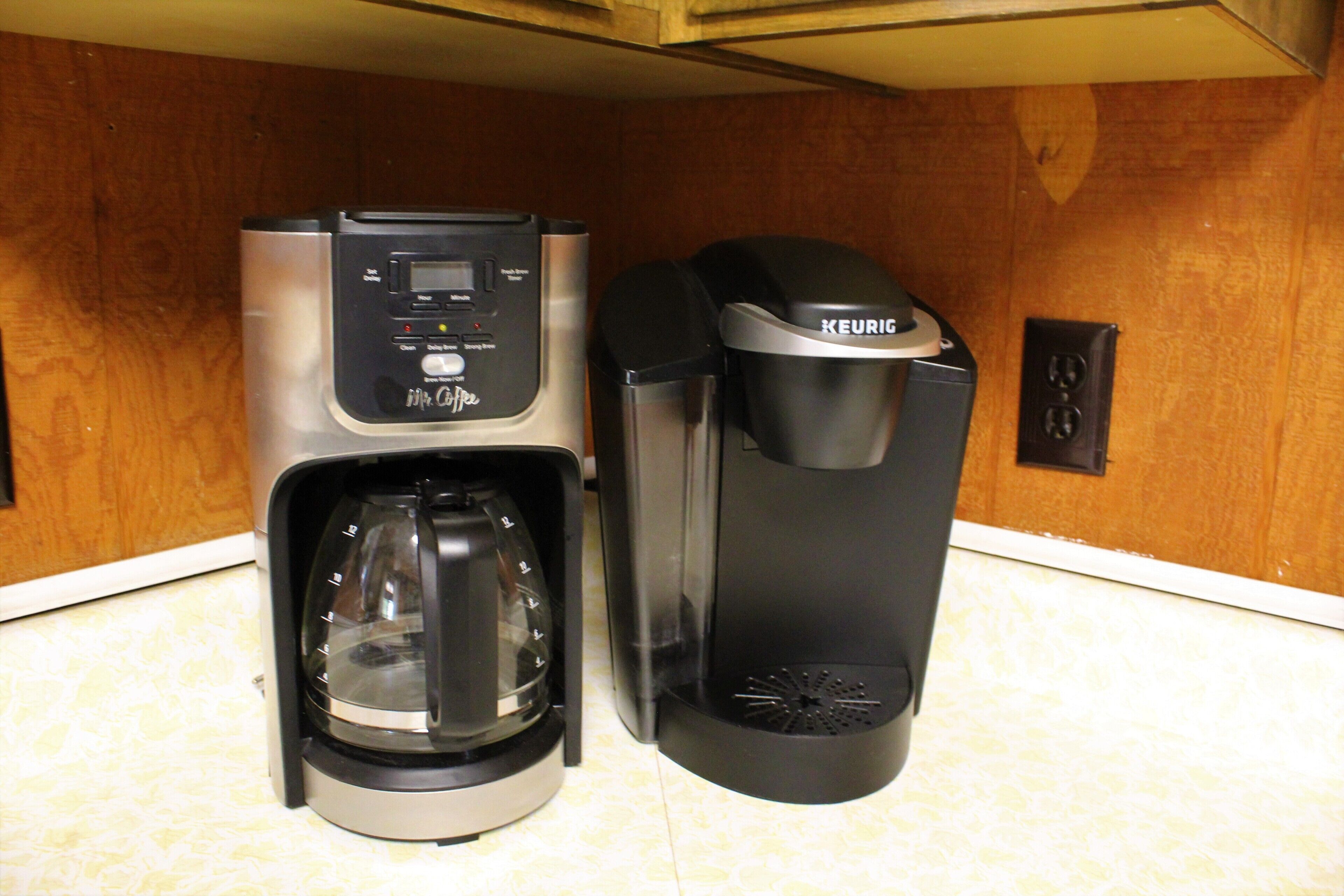 Une machine à café classique et une machine à café Keurig sont posées sur le plan de travail de la cuisine.