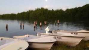 A row of boats docked at a calm body of water with a forested shoreline in the background. - spacious ground floor of 200m² in villa with private pool (Morne à l'Eau)