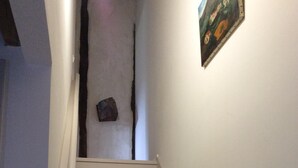 A staircase with white walls and a framed picture on the right. - Apartment in Basque house (Sare)