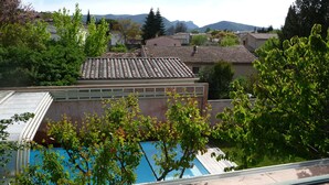 A residential area with houses, a swimming pool, and a view of mountains in the background.