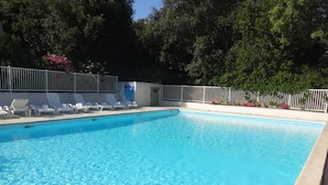 A rectangular swimming pool with clear blue water, surrounded by a white fence and white lounge chairs. - I mini villa 4/6 pers with swimming pool in Porto vecchio (Porto-Vecchio)