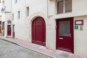 A building with a red door and a plaque indicating it is a 'Sweet Home' with amenities like a gym and a pool.